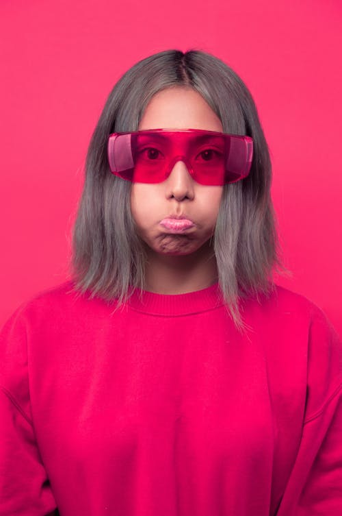 Frowning Woman Wearing Pink Shirt and Sunglasses