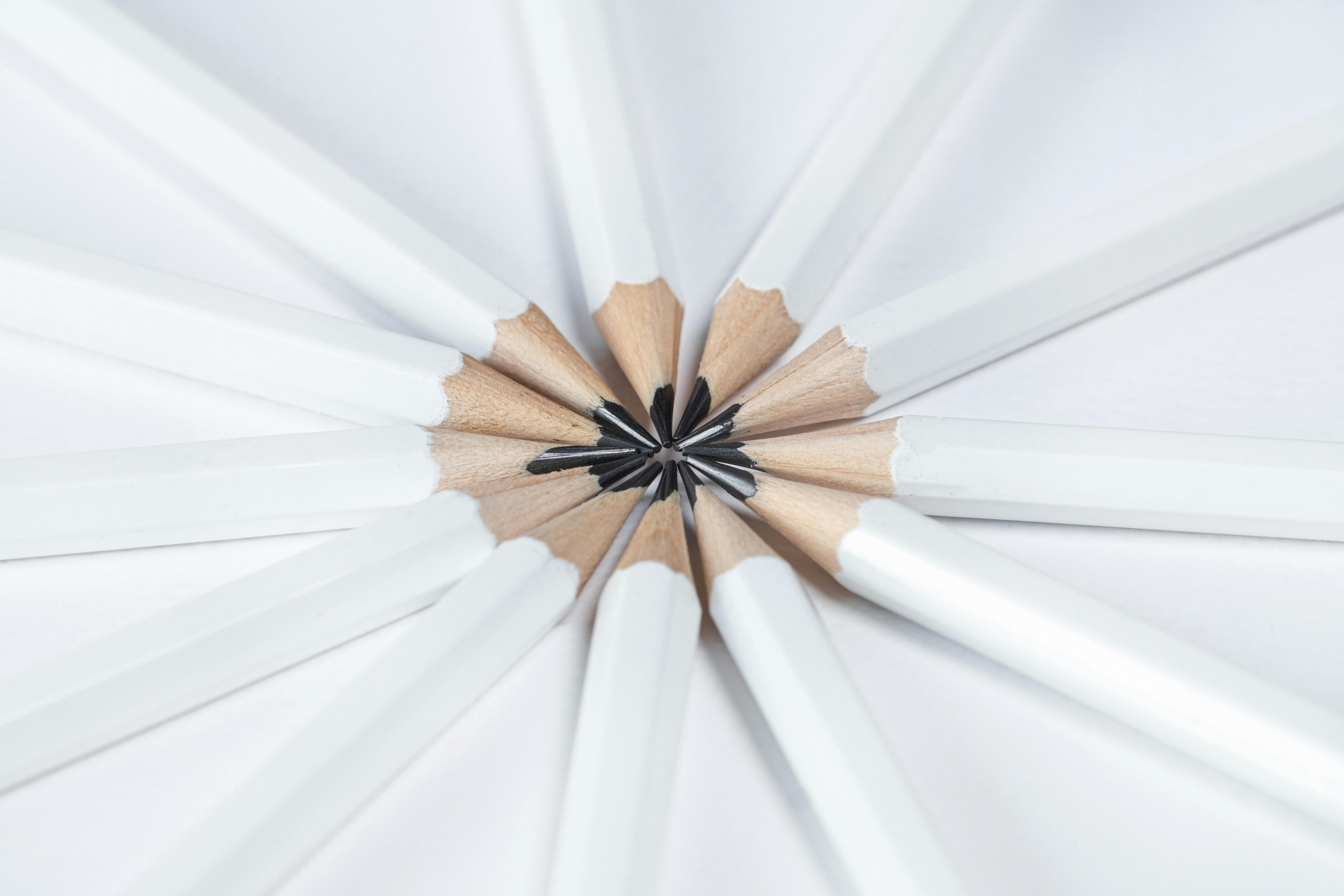 Top view of white pencils arranged in a radial pattern on a white background, emphasizing harmony and creativity.