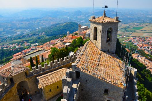 A stunning aerial view of a medieval castle in San Marino, Italy with scenic landscapes.
