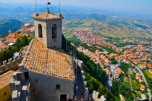 Breathtaking aerial photo of Guaita Tower and San Marino cityscape under clear skies.