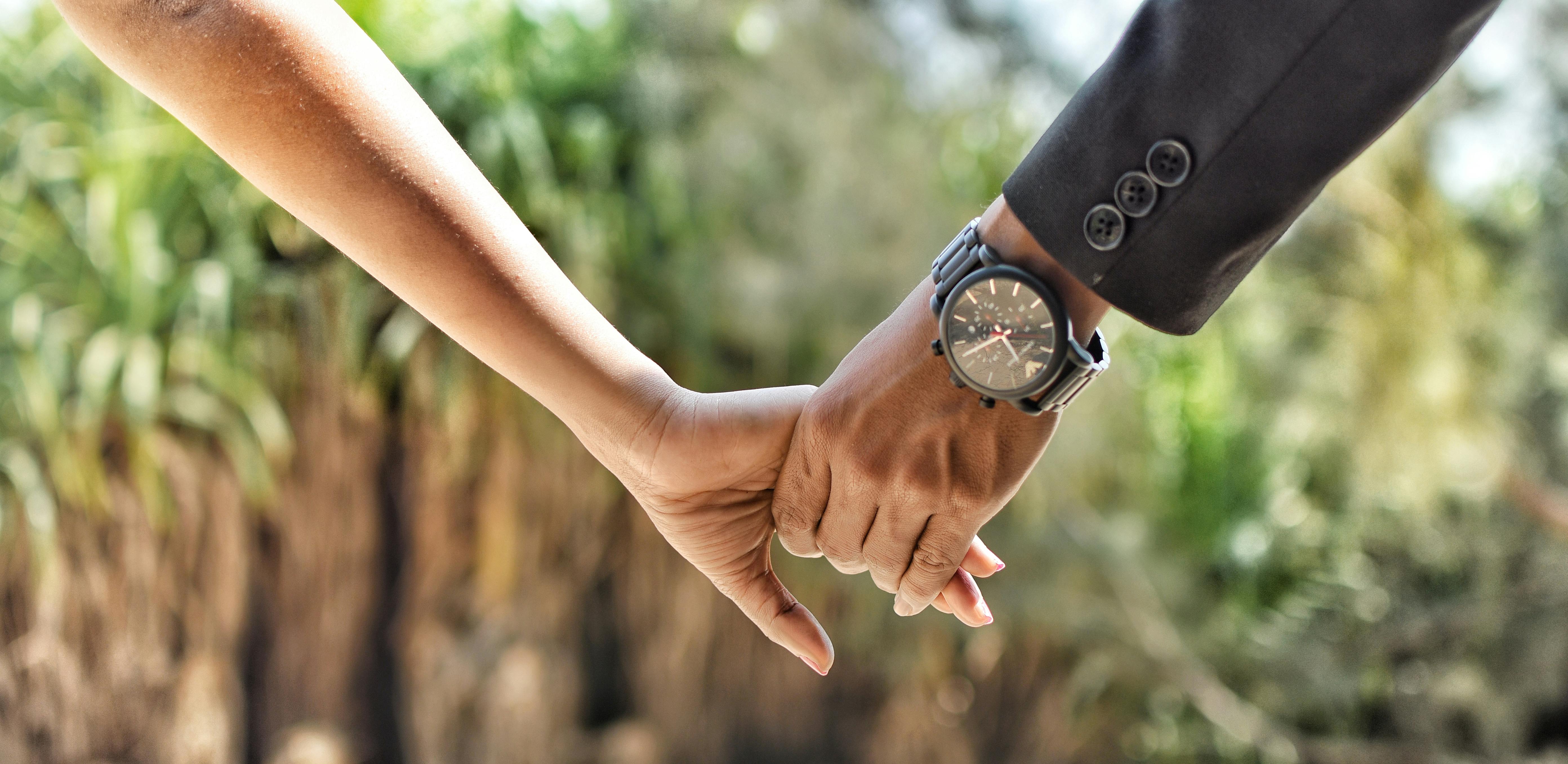 Free Romantic close-up of a couple holding hands in an outdoor setting, conveying love and connection. Stock Photo