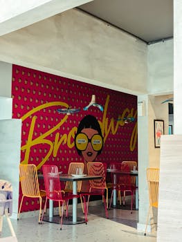 Colorful café interior in Karachi featuring an artistic wall mural with 'Broadway' text.