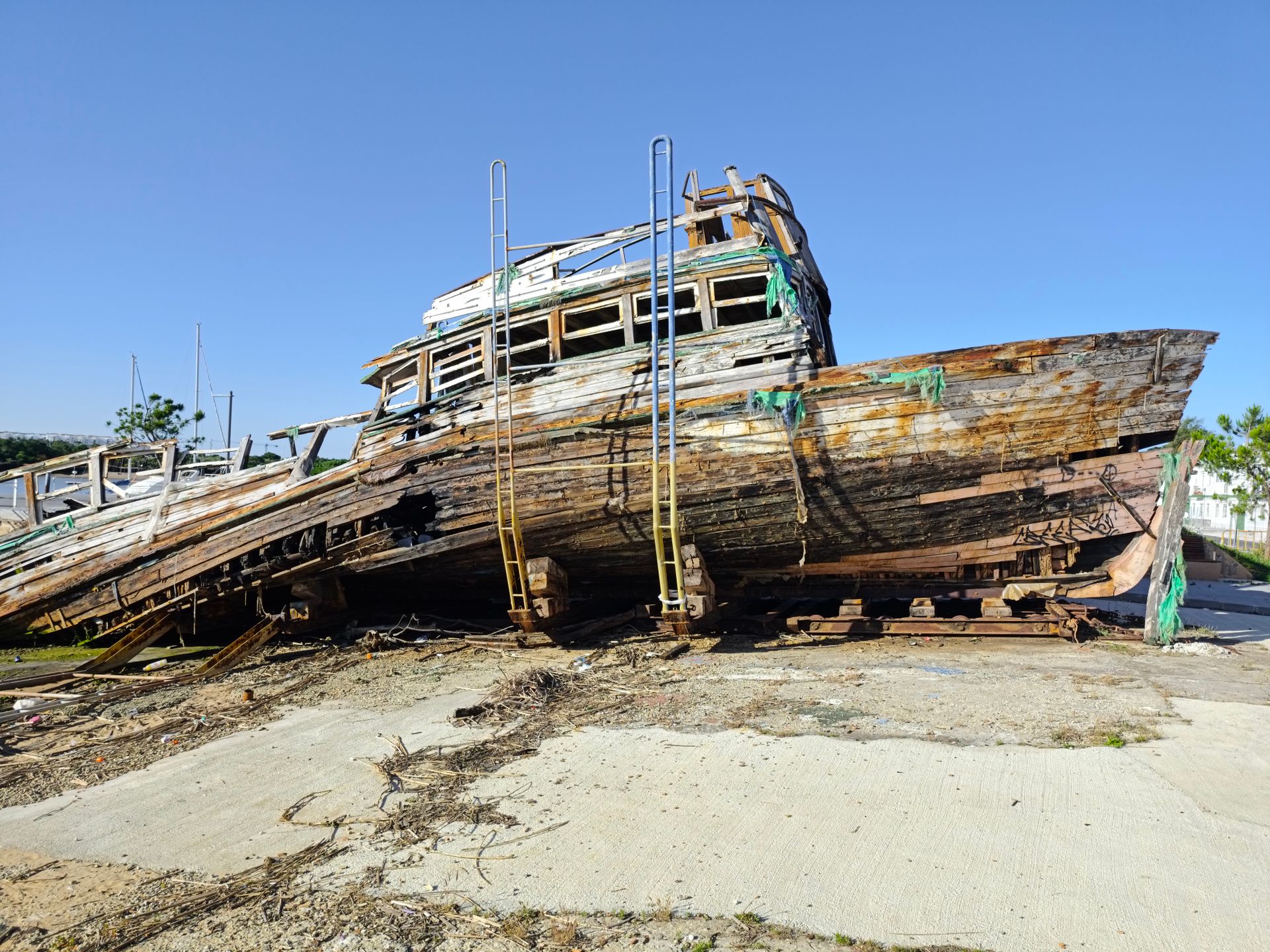 Explore a rustic abandoned shipwreck in El Puerto de Santa María, showcasing maritime decay against a clear sky.