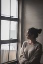 Woman Wearing White Sweater Standing Beside Window