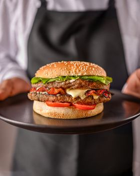 Mouthwatering gourmet cheeseburger with fresh lettuce, tomato, and cheese perfectly presented.