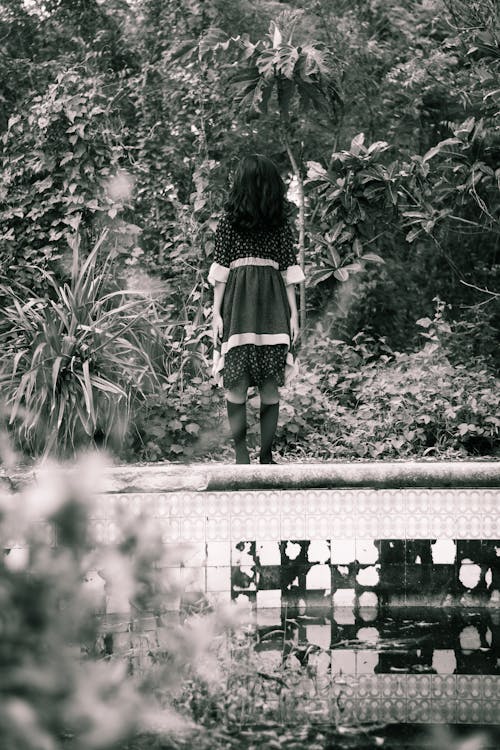 Woman in Black Dress Standing on Wall