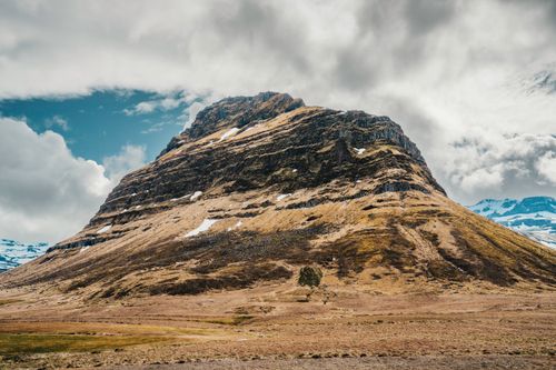Free Breathtaking view of an Icelandic mountain against a dramatic cloudy sky, showcasing nature's raw beauty. Stock Photo
