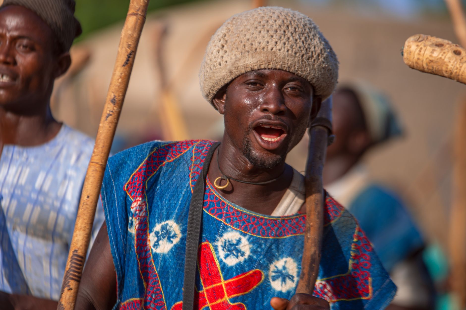 Vibrant portrait of African dancers performing with traditional musical instruments under the sun.