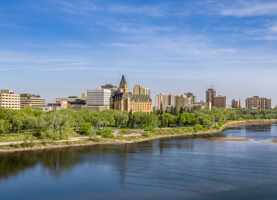 A beautiful spring view of Saskatoon cityscape with a river and reflections.
