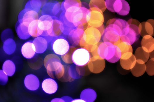 Vibrant bokeh effect with purple and orange lights creating an abstract and artistic pattern.