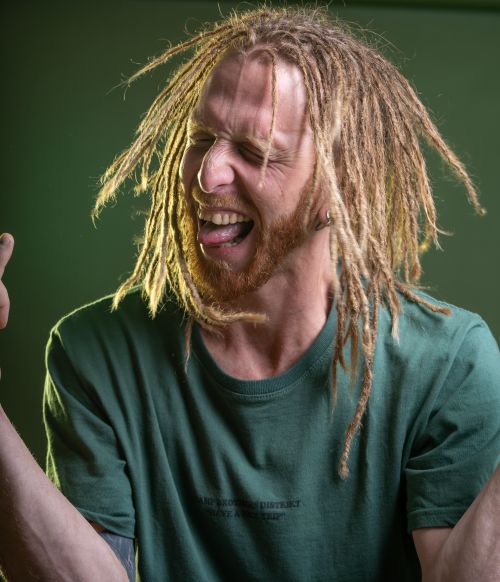 Free Dynamic portrait of a man joyfully expressing himself with dreadlocks and a vibrant personality. Stock Photo