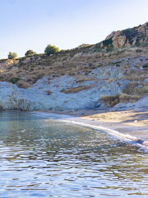 Free Explore a tranquil rocky coastline with clear water and a bright sky. Stock Photo