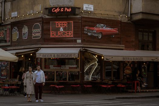 Evening street photography capturing people outside Beer & Burger in Budapest, Hungary.