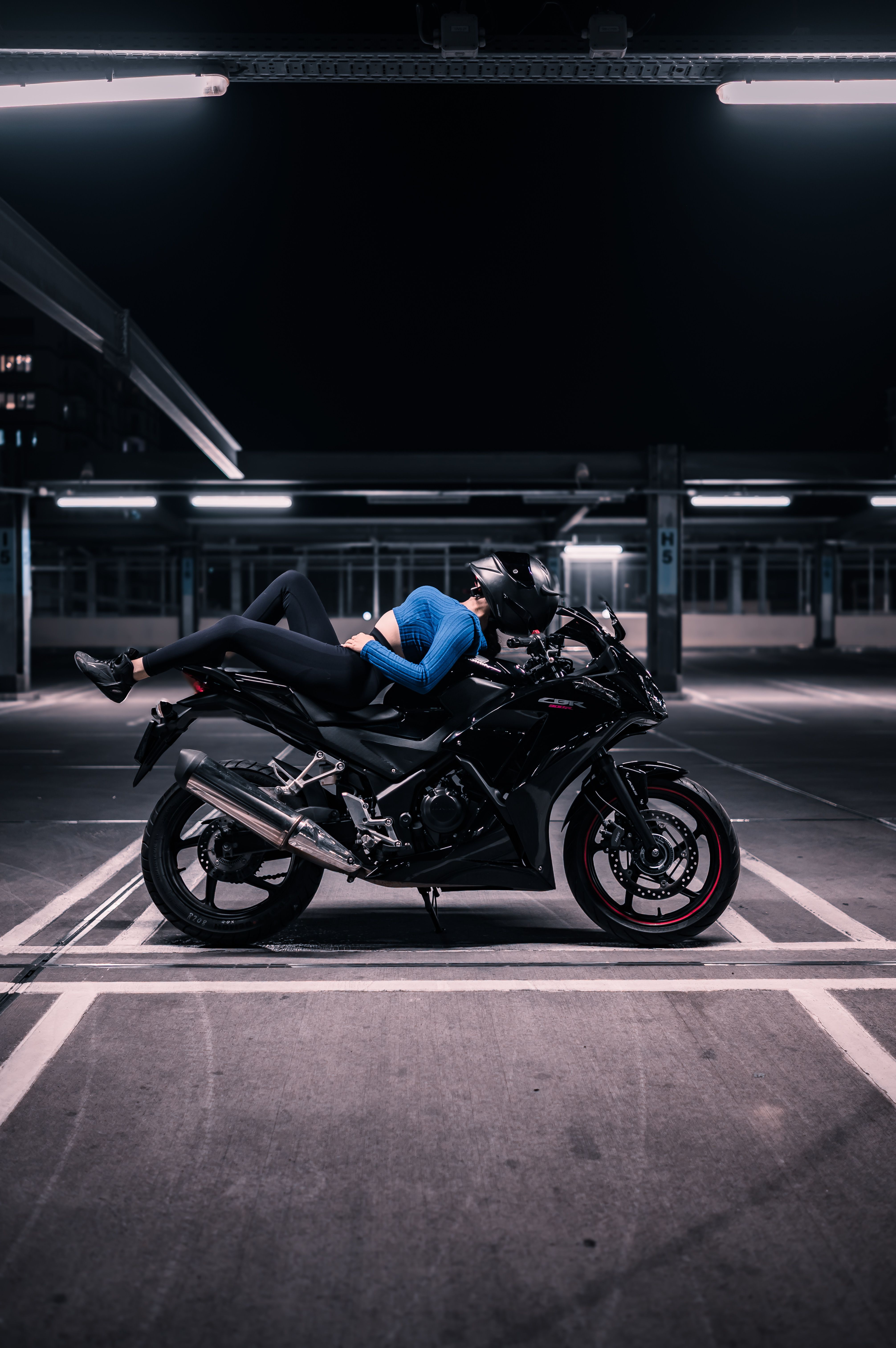 Motorcyclist Relaxing on Bike in Empty Parking Lot · Free Stock Photo