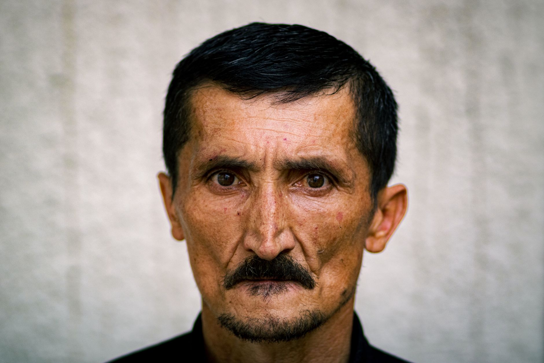 Close-up portrait of a mature man with expressive eyes and rugged features, highlighting depth and character.