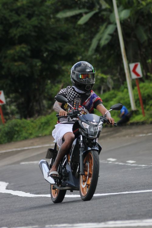 Free A motorcyclist skillfully navigates a curve on a scenic rural road, showcasing agility and control. Stock Photo