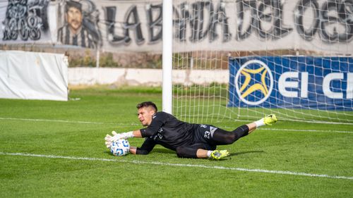 Free A goalkeeper in action making a dive save during a football match, showcasing skill and agility. Stock Photo