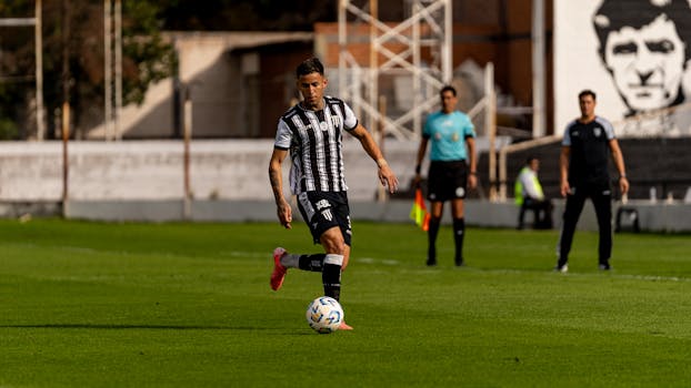 Soccer player dribbling the ball during a daytime outdoor match.
