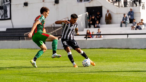 Dynamic action shot of two football players during a competitive match outdoors.
