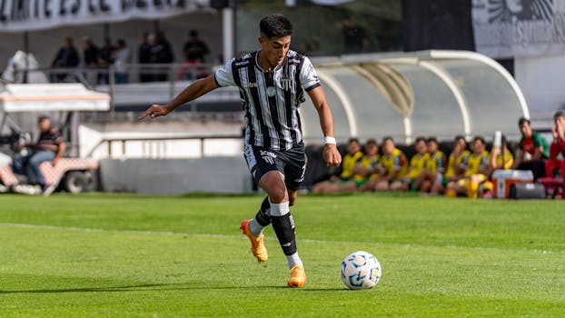 An athletic soccer player in motion during a game on a green field.
