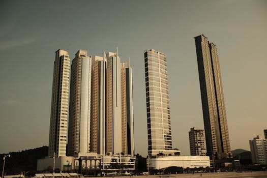 Dramatic view of modern skyscrapers under a warm evening sky, highlighting urban architecture.