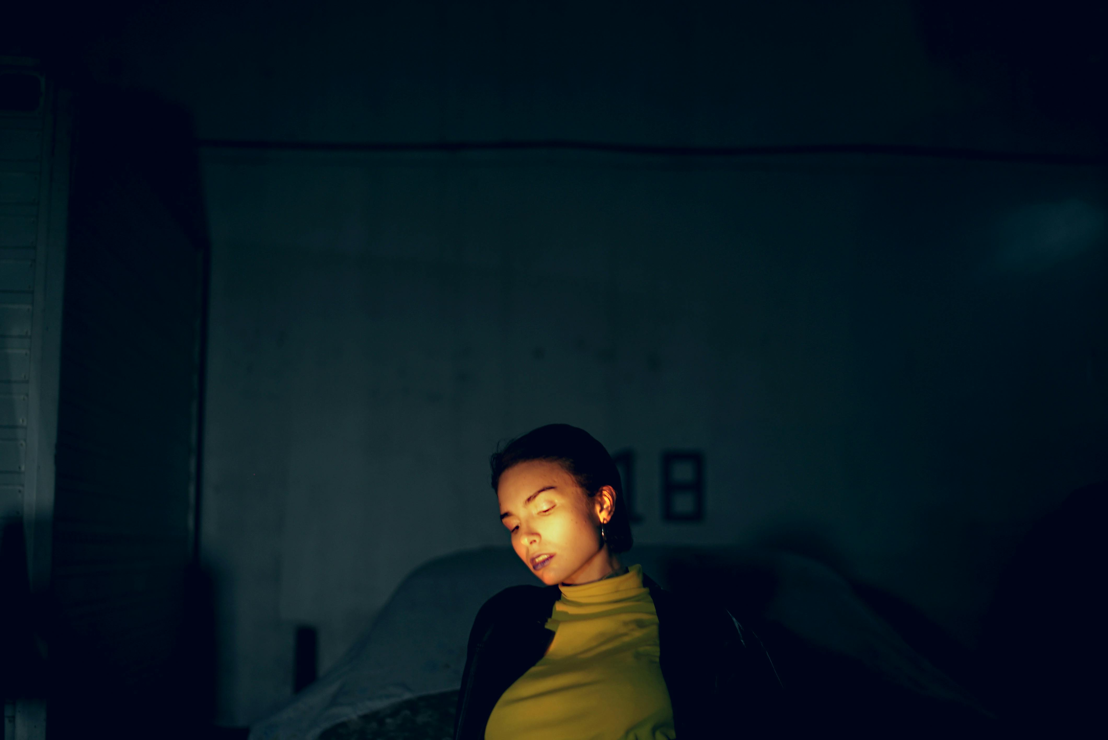 Gratuit Portrait captivant d'une femme dans un éclairage doux et tamisé créant une atmosphère énigmatique. Photos