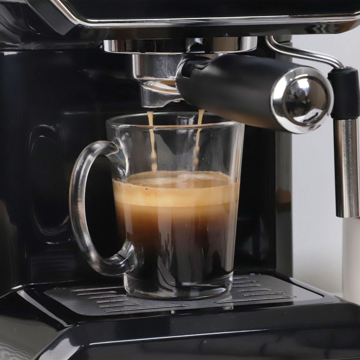 Foto: gavi — Pexels Prim-plan cu un shot de espresso curgând în ceașcă de porțelan, crema densă vizibilă, tonuri calde închise