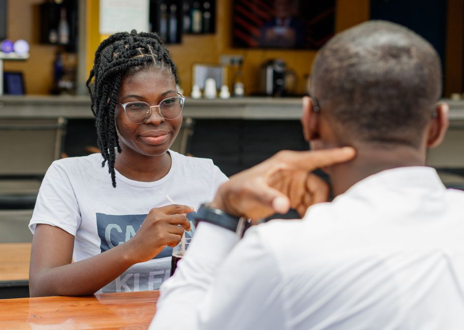 A couple engaging in conversation at an outdoor cafe in Accra, Ghana.
