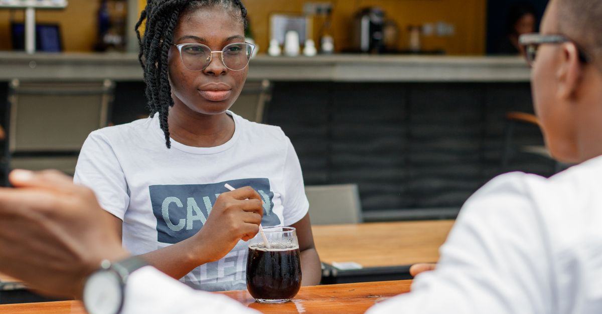 Two teenagers having a calm, respectful discussion at a table, not arguing angrily