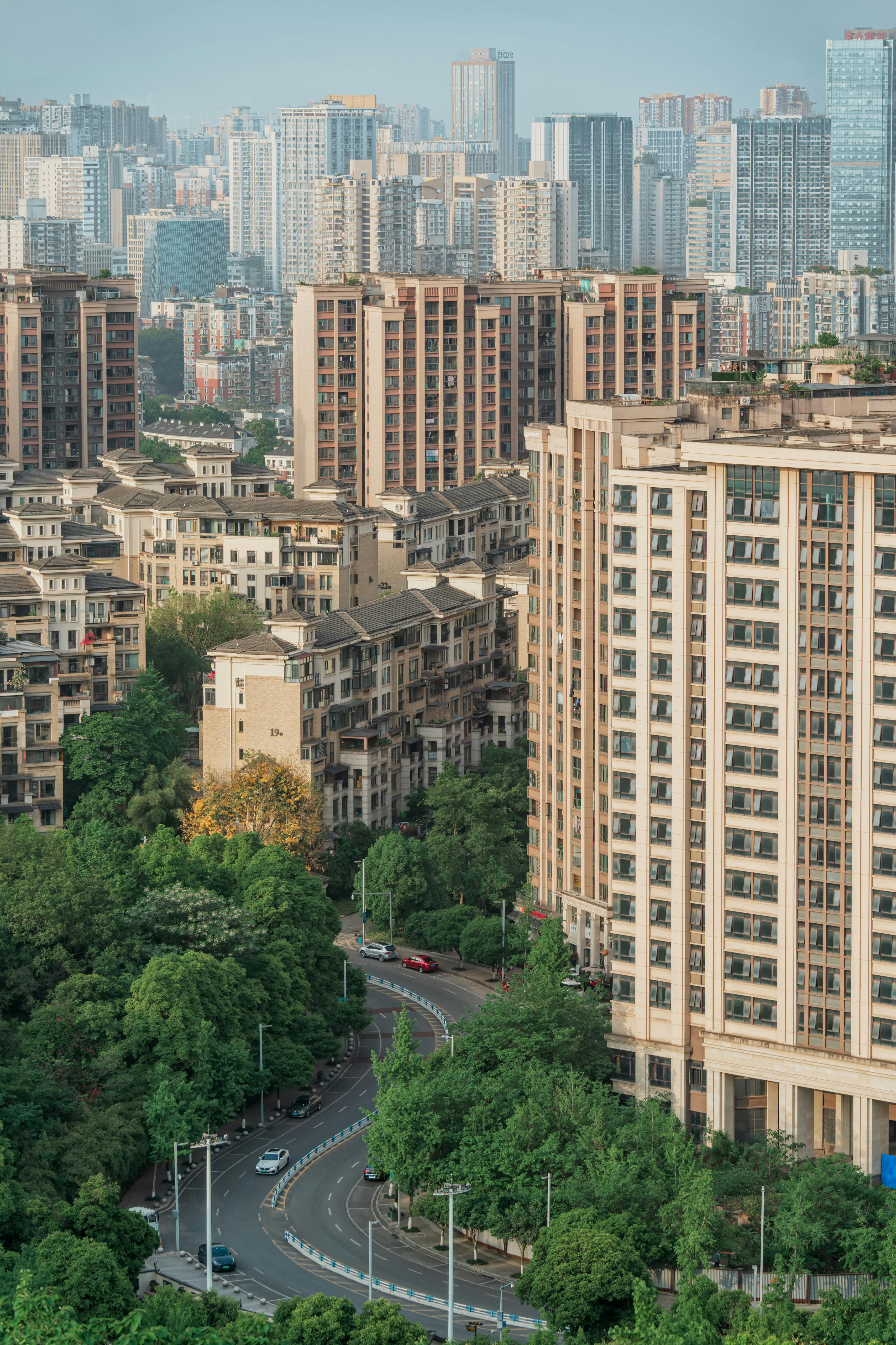 High-rise residential buildings and lush greenery in a modern urban cityscape.