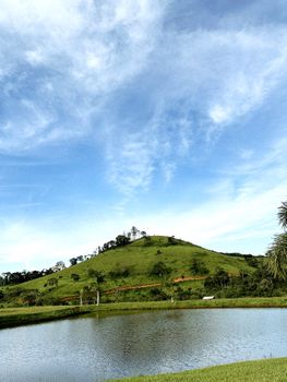 A tranquil landscape showcasing a lush green mountain beneath a bright blue sky. Perfect for nature themes.
