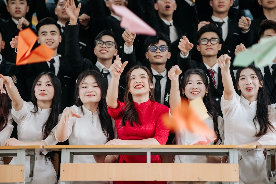 幸せな卒業生たちは室内で紙飛行機を飛ばして熱狂的に祝います。