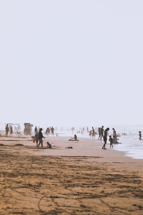 Free A summer day with families on a sandy beach, relaxing and playing. Stock Photo