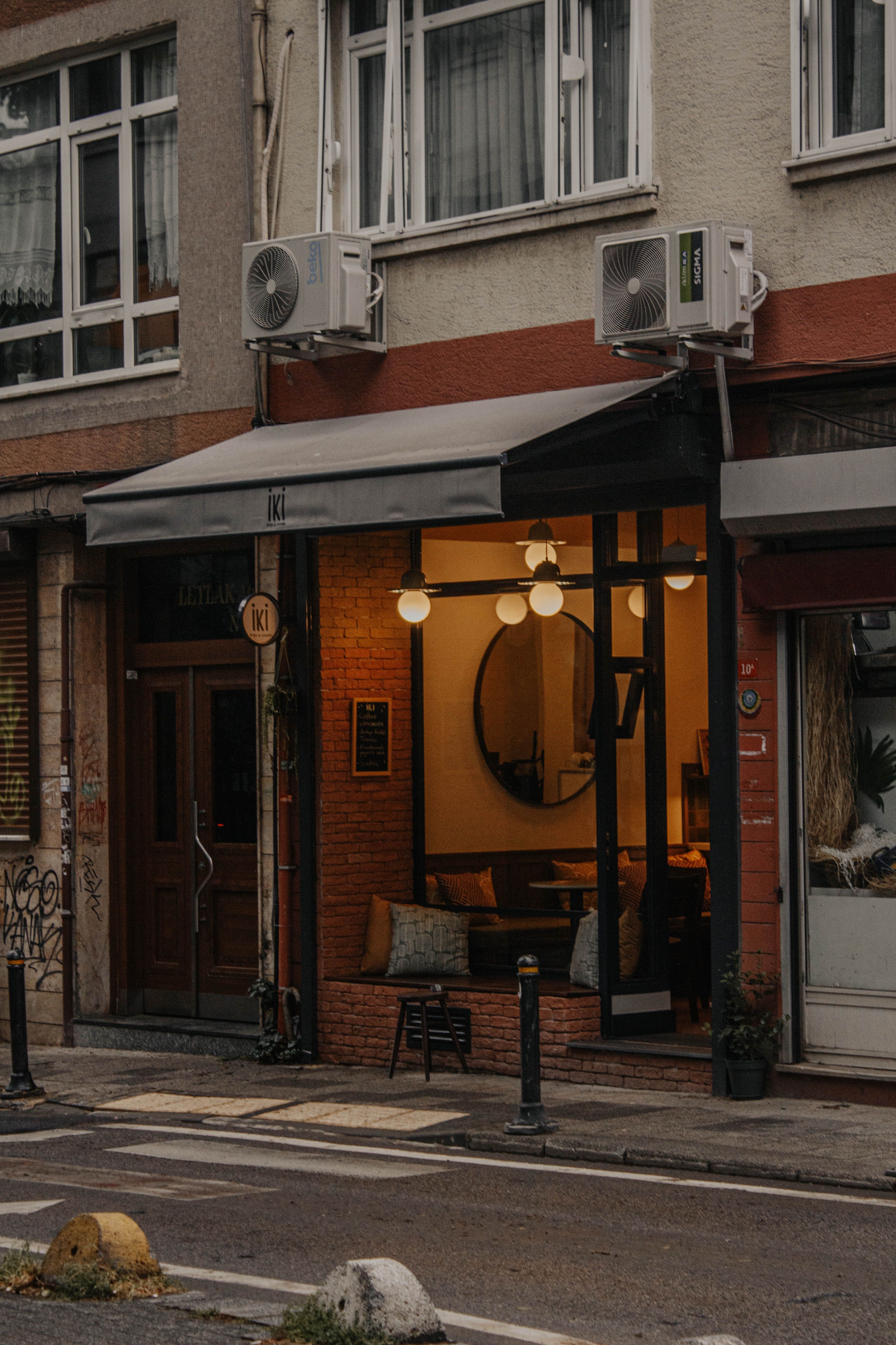 Charming café exterior in Istanbul with warm lighting, inviting street view.