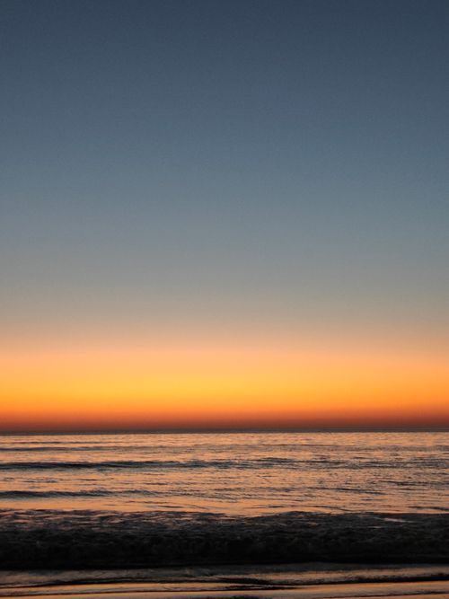 Free Captivating ocean sunset with vivid oranges and blues creating a serene horizon. Stock Photo