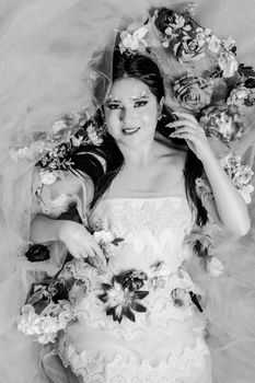 Stunning black and white portrait of a woman enveloped in floral elegance, showcasing artistic expression.