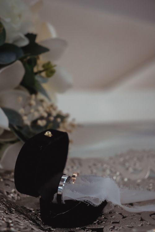 Free A stunning wedding ring inside a black velvet box, surrounded by white flowers, symbolizing love and commitment. Stock Photo