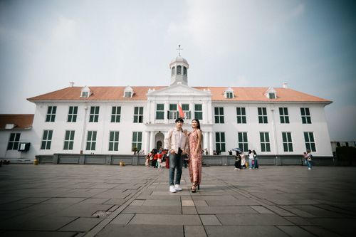 Free A stylish couple poses in front of Fatahillah Museum in Jakarta's old town square. Stock Photo