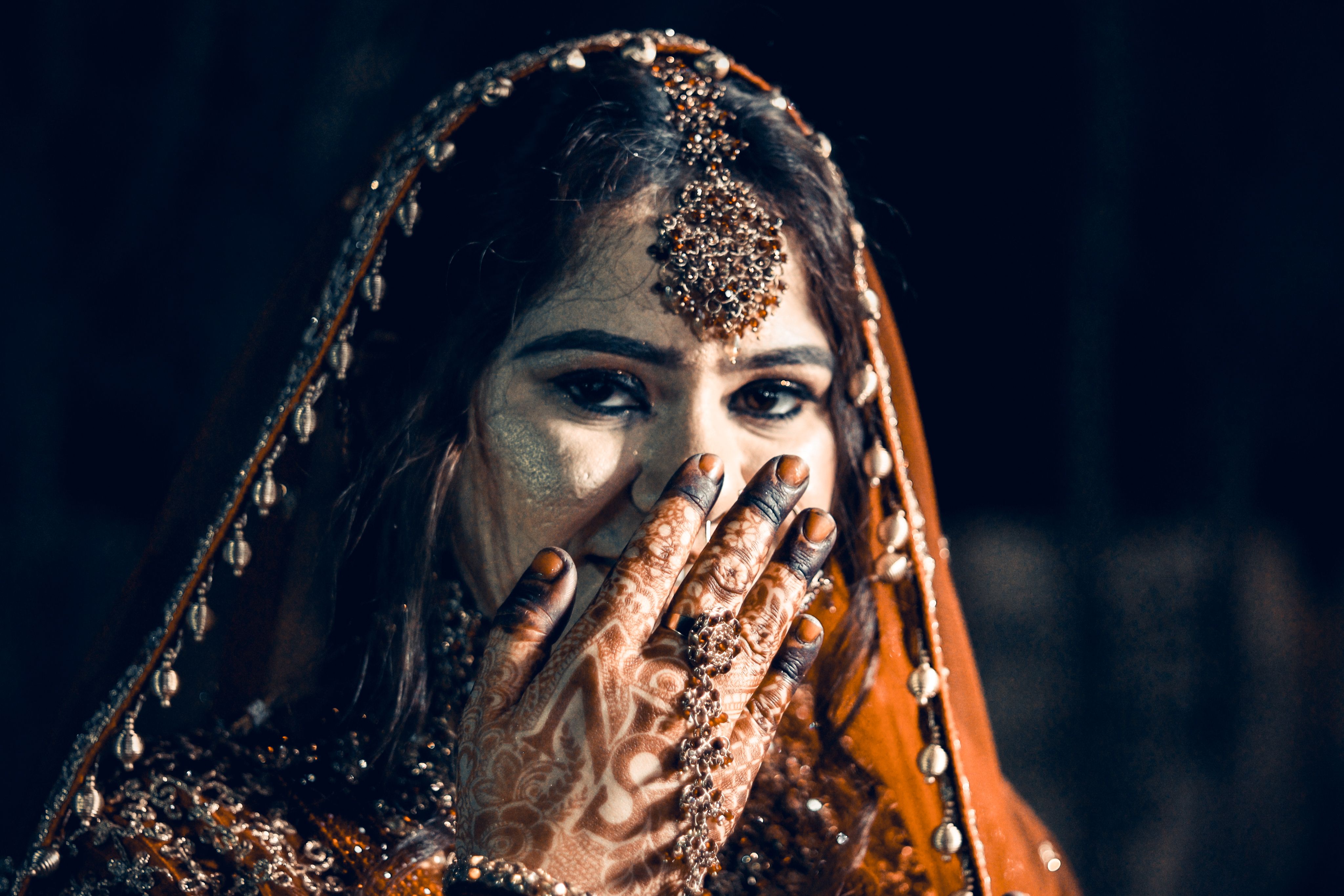 Beautiful Indian bride adorned with traditional jewelry and intricate henna designs at her wedding.