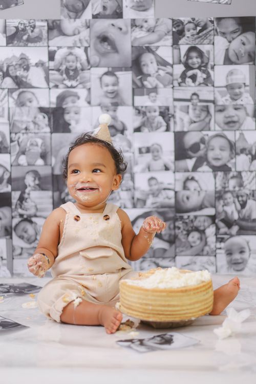 Free Delightful baby enjoying a playful cake smash session indoors, set in Dubai. Stock Photo