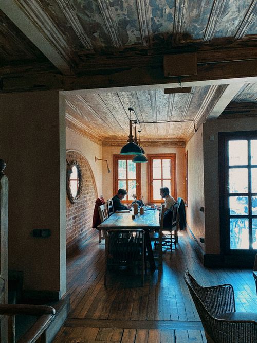 Free Warm, rustic café interior with two people enjoying a meal by the window. Stock Photo