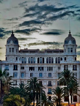 Stately historic building in Alicante, Spain with dramatic twilight sky.