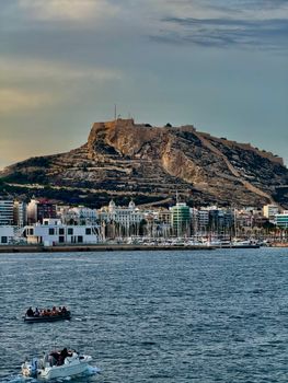 Scenic view of Alicante harbor with Santa Bárbara Castle on a sunny day.