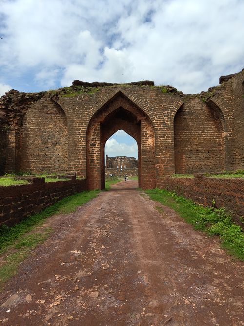 Free Explore the ancient architecture of Bidar Fort with a stunning arched entrance under a bright blue sky. Stock Photo