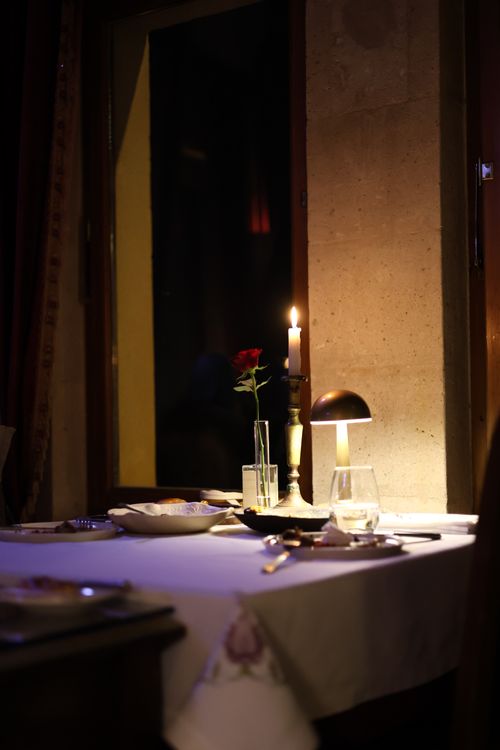 Free Cozy candlelit dinner table with a single rose, creating a romantic atmosphere. Stock Photo