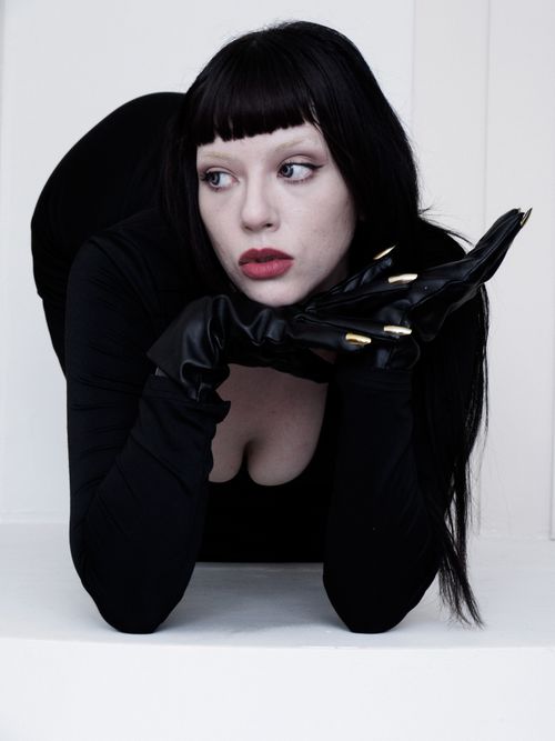 Free Dramatic portrait of a woman in gothic style with black attire and gloves, exuding mystery and elegance. Stock Photo
