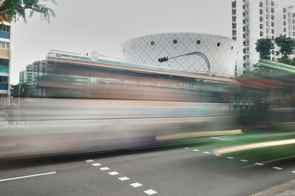 Dynamic urban scene with buses in motion, showcasing city life and architecture.