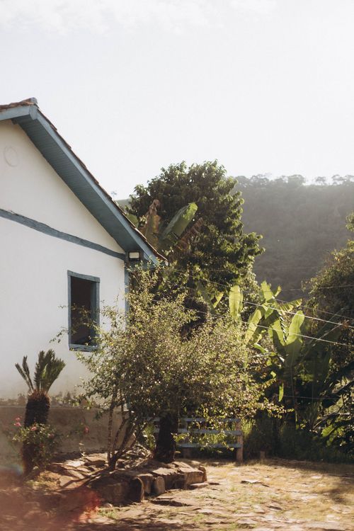 Free A picturesque countryside house with a sunlit garden, perfect for a tranquil escape. Stock Photo