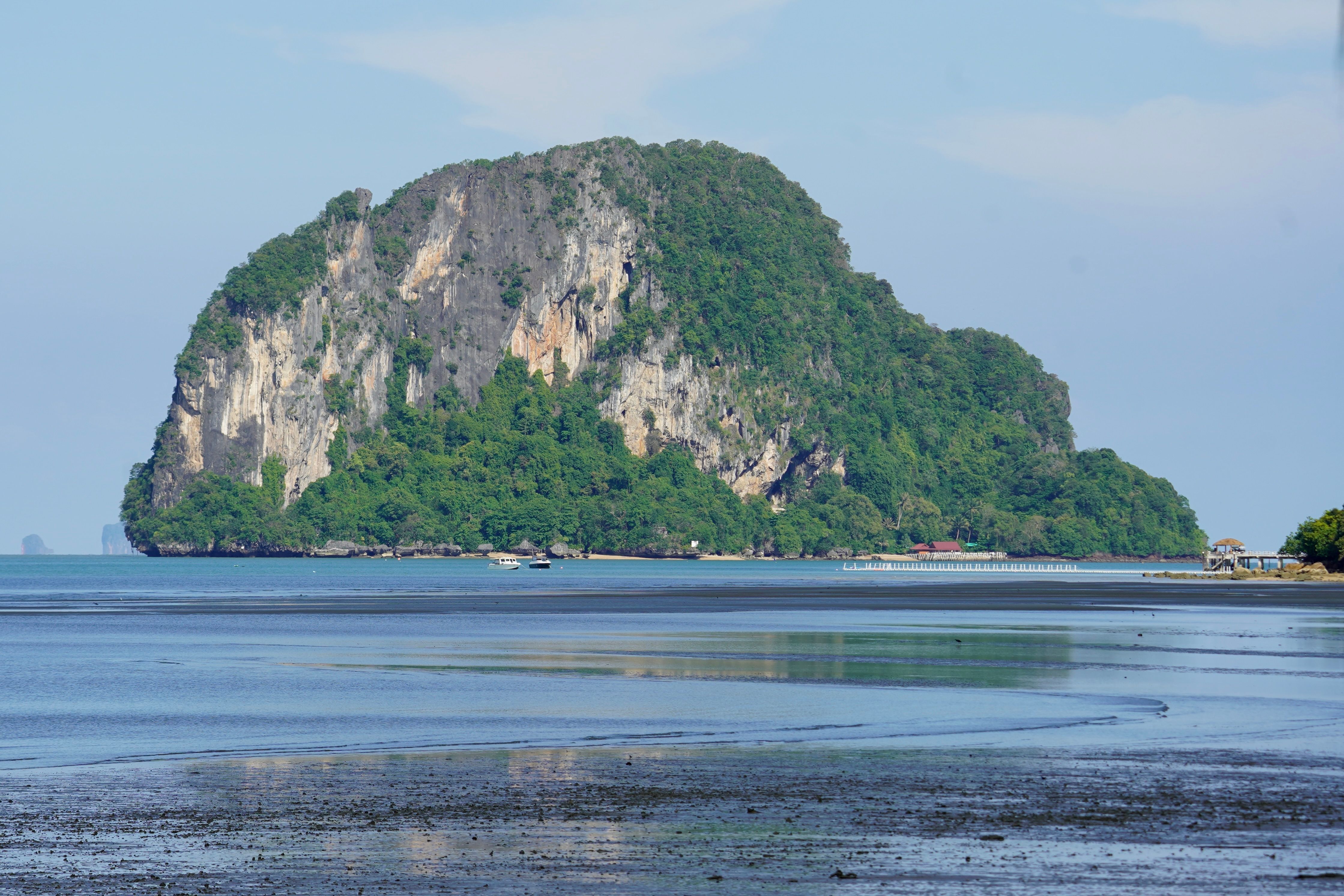 A picturesque island surrounded by clear blue waters under a bright sunny sky, ideal for nature lovers.