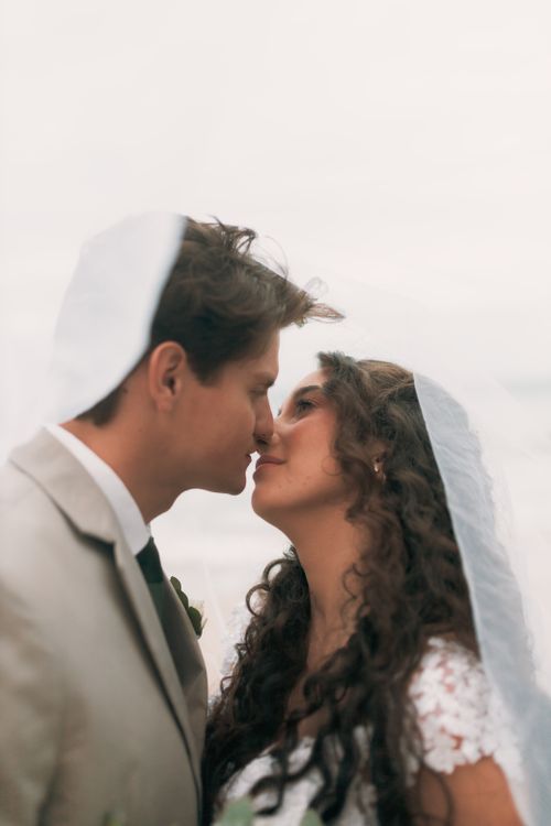 Free A romantic close-up of a bride and groom about to kiss outdoors, exuding love and joy. Stock Photo